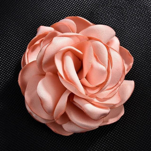 coral pink brooch on black background