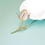 golden rose brooch on green background