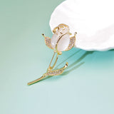 golden rose brooch on green background