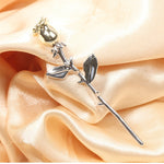 rose gold flower brooch pink background